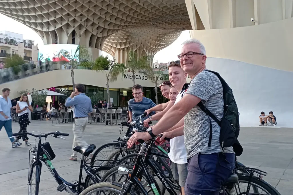 A bike tour stopping under the Metropol Parasol in Seville