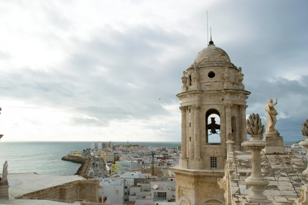 Bell tower of Cadiz Cathedral above the rooftops and the Atlantic