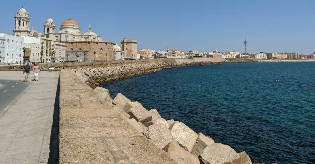 Seafront promenade in Cadiz curving towards the cathedral dome