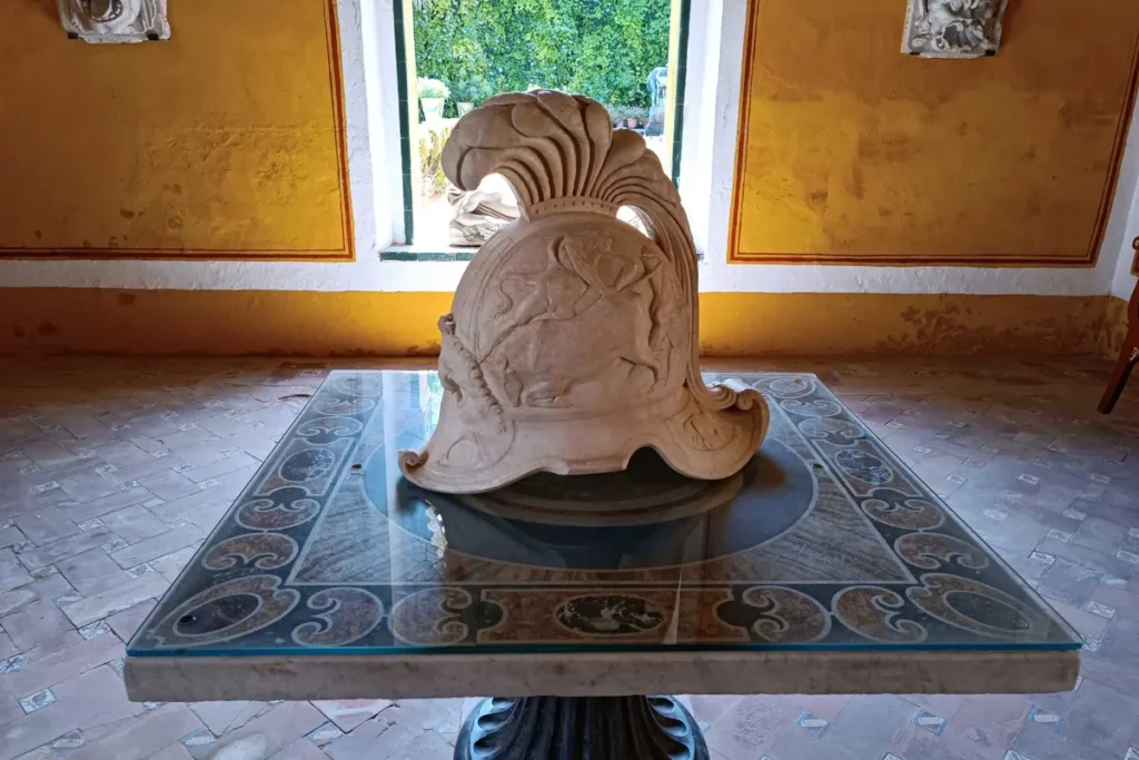 Carved marble piece displayed by a window at the Casa de Pilatos in Seville