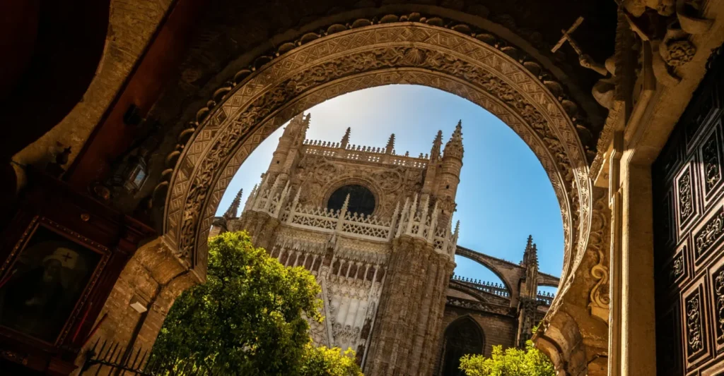 Seville Cathedral framed by an arch and orange trees