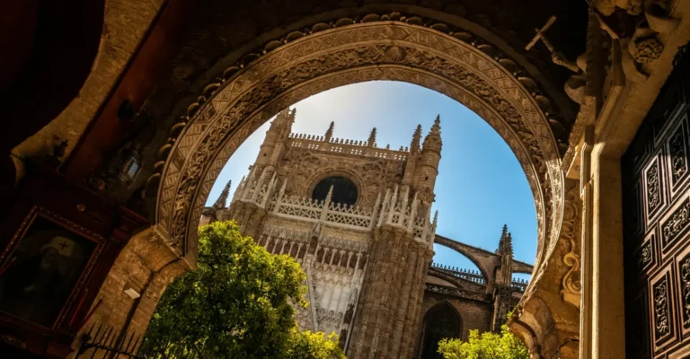 Seville Cathedral framed by an arch and orange trees