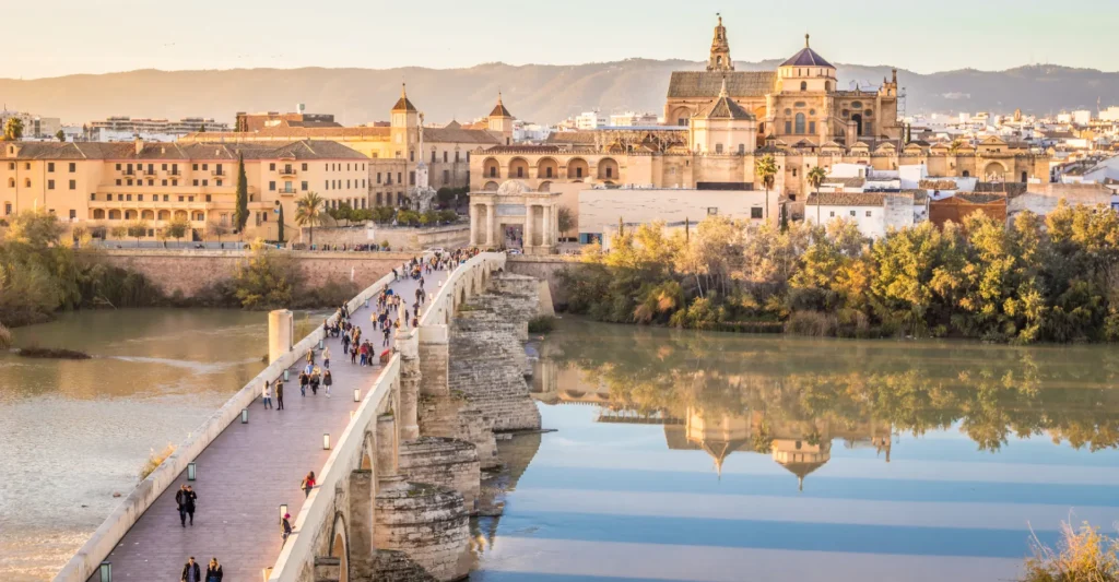 The Roman bridge of Cordoba and the city skyline reflected at sunset