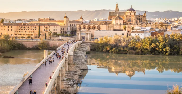 The Roman bridge of Cordoba and the city skyline reflected at sunset
