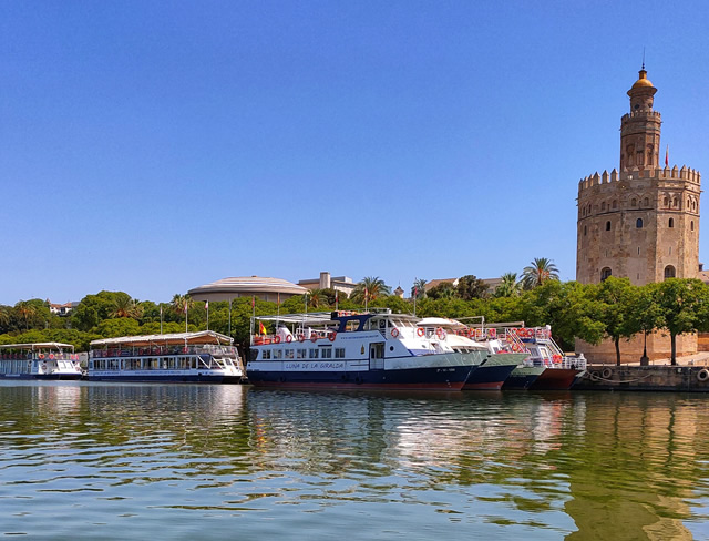 Sightseeing boats moored on the Guadalquivir below the Torre del Oro