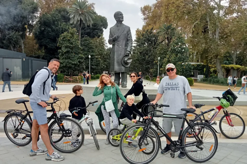 Cyclists resting by a statue in the Maria Luisa park in Seville