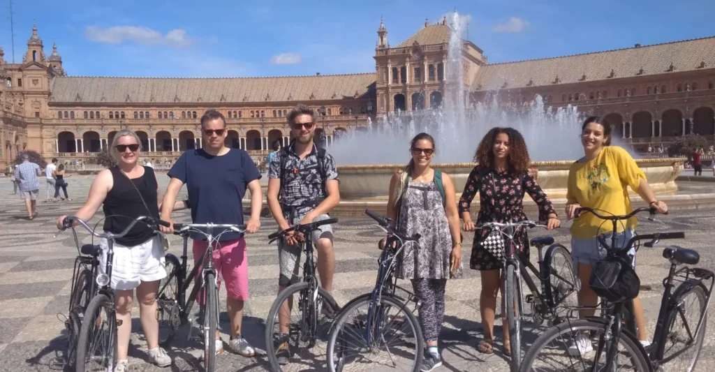Cyclists beside a fountain in the Maria Luisa park in Seville