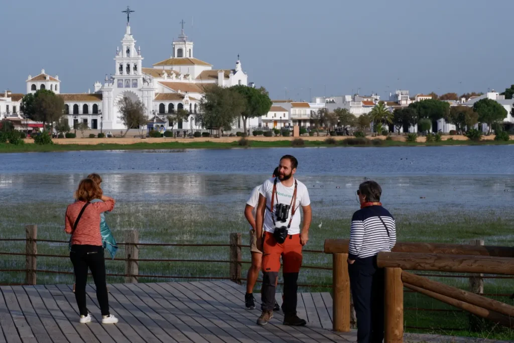 The white hermitage of El Rocio reflected across the marsh in Donana