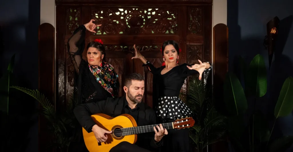 Two flamenco dancers and a guitarist on stage in Triana, Seville