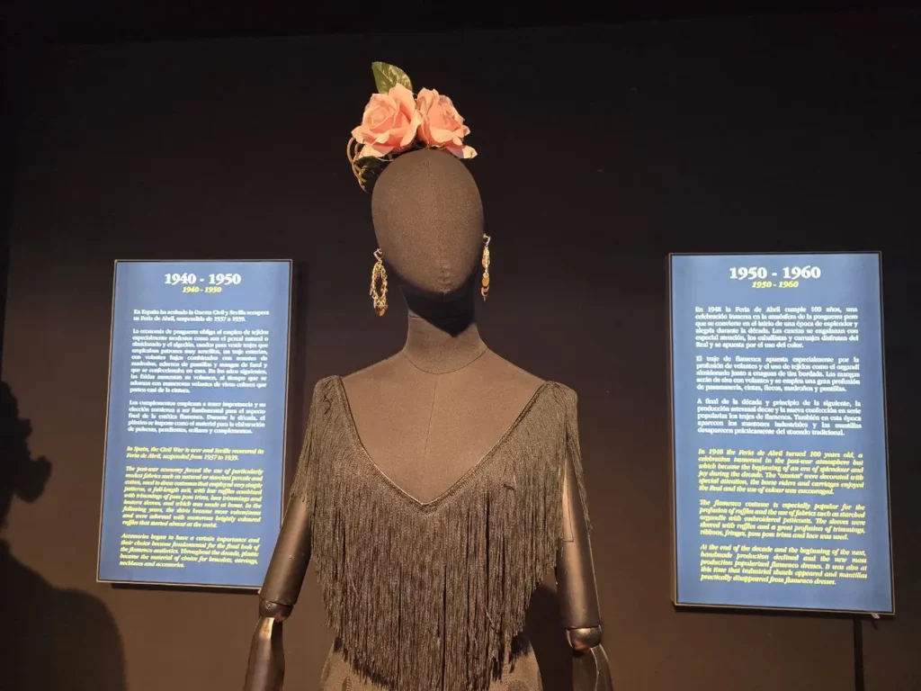 A flamenco dress from the mid 20th century displayed beside its label