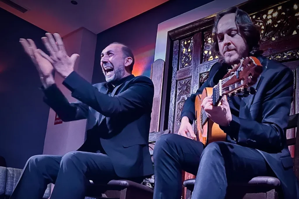 A flamenco singer and guitarist performing at a tablao in Triana, Seville
