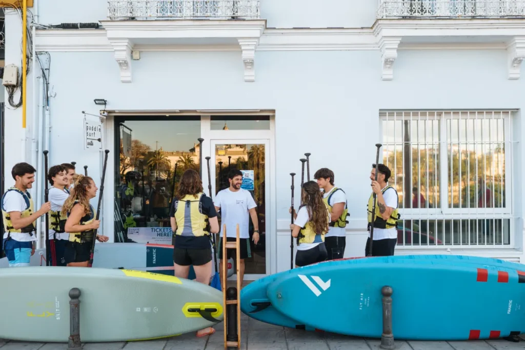 A group getting their paddleboards ready beside the river in Seville