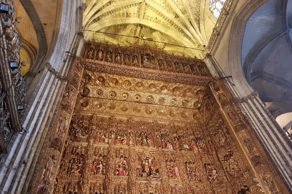 Gilded altarpiece rising under the vaults of Seville Cathedral