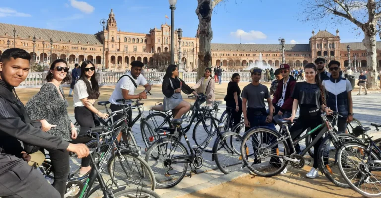 A group with hire bikes in front of the Plaza de Espana in Seville