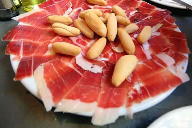 A plate of Iberian ham with breadsticks