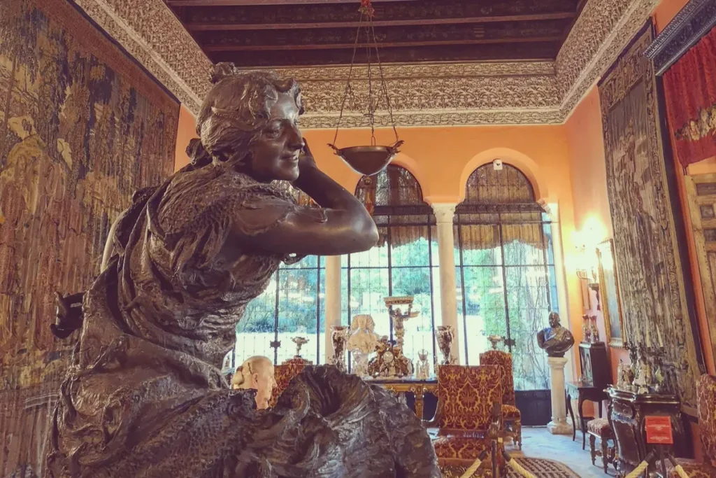 A furnished room with sculpture inside the Palacio de las Duenas in Seville