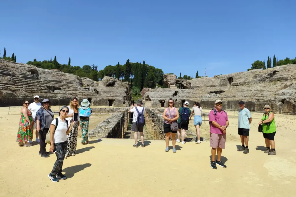 Visitors standing on the arena floor of the amphitheatre at Italica