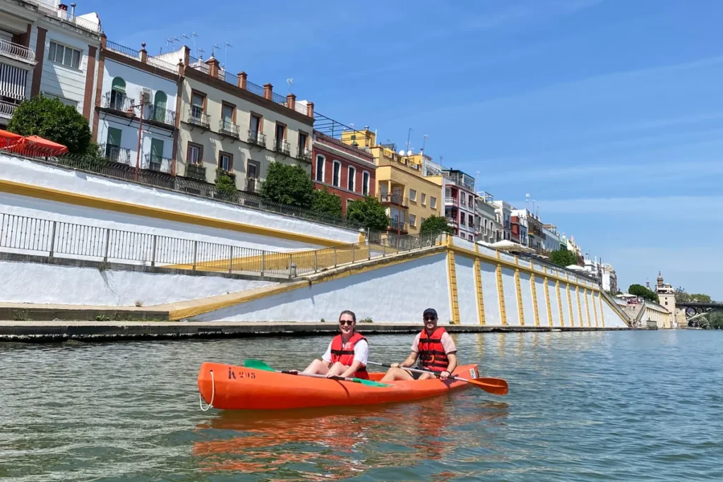 A kayak passing the coloured house fronts of Triana on the Guadalquivir