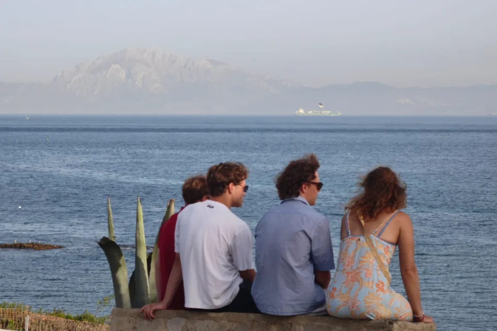 Visitors on a Tarifa viewpoint looking across the strait to Africa