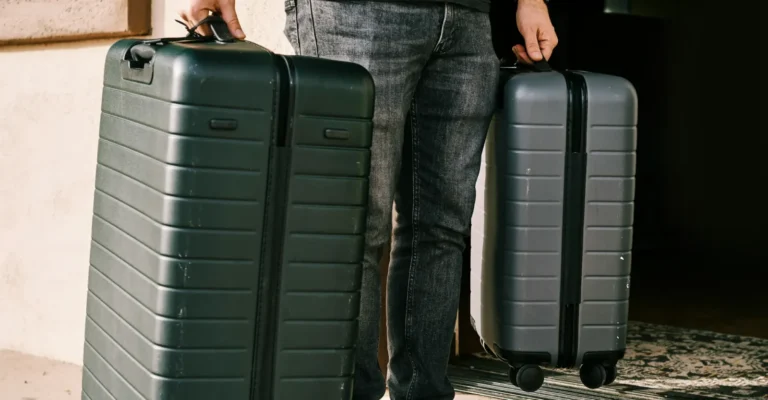 Two travellers carrying suitcases in to be stored