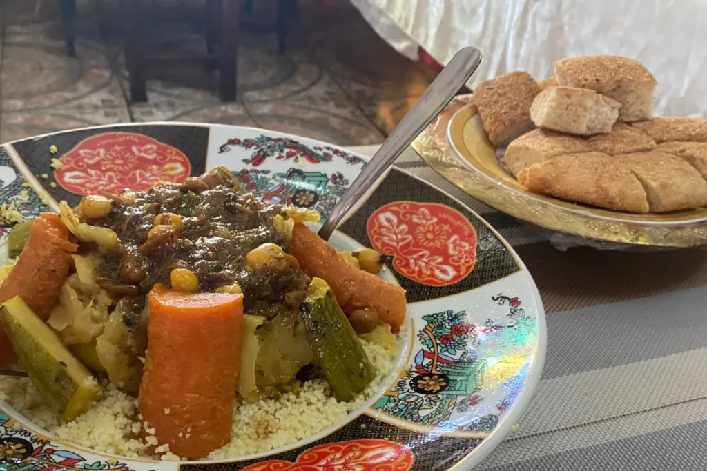 A plate of Moroccan couscous with vegetables served with flatbread