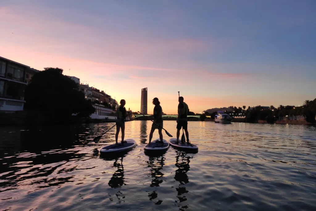 Paddleboarders silhouetted on the Guadalquivir at sunset in Seville