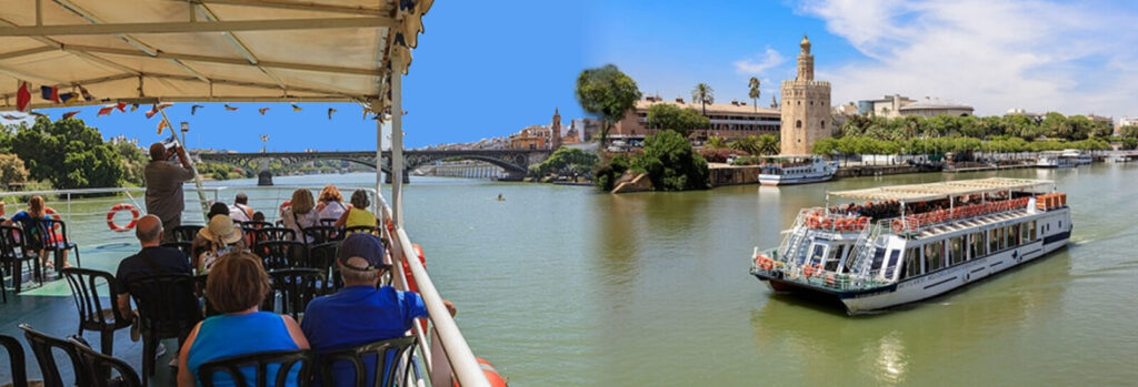 Passengers on the open deck of a river boat looking at the Torre del Oro