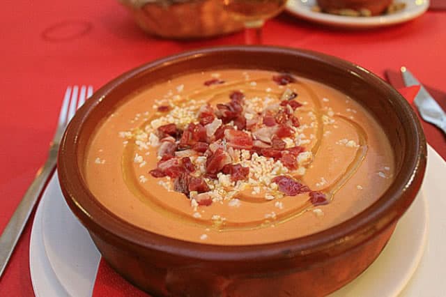 A bowl of salmorejo, the cold tomato soup of Andalusia, topped with ham