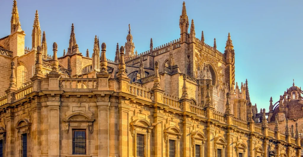 The exterior of Seville Cathedral lit by low golden light