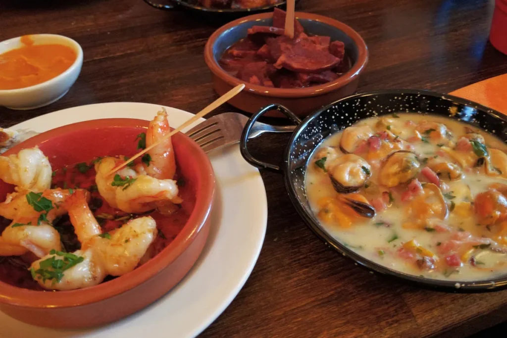 Several tapas laid out on a table in a traditional bar in Seville