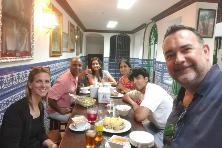 Travelers sharing lunch around a table in an Andalusian tavern