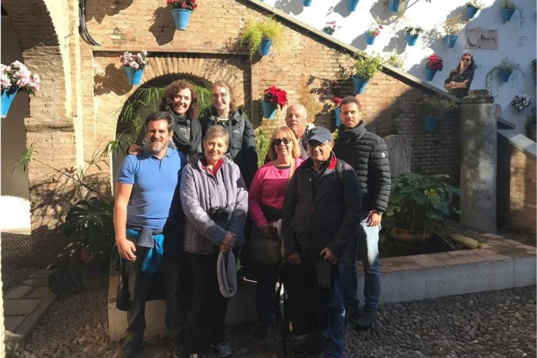 A group of travelers under a brick archway in an Andalusian patio