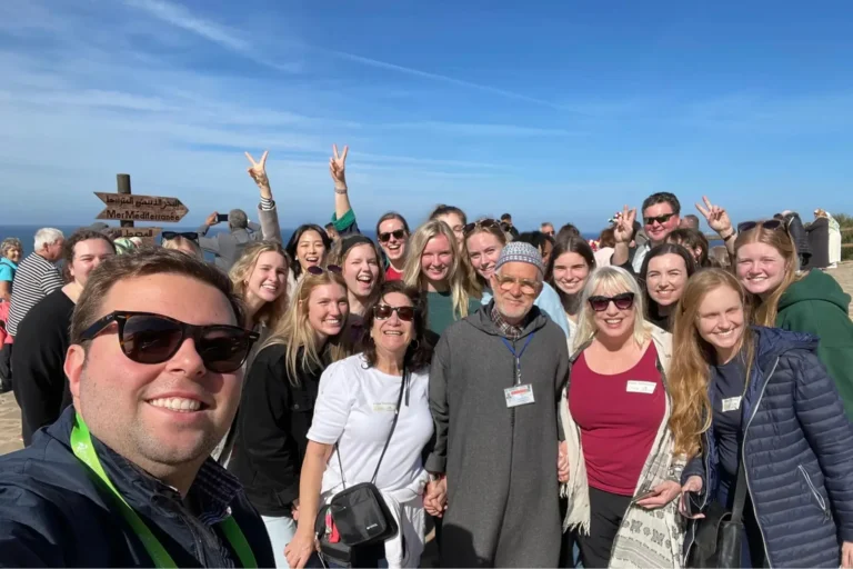 Travelers taking a selfie at a coastal viewpoint on a day trip
