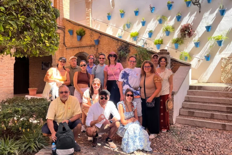 A group of travelers in an Andalusian patio decorated with blue flowerpots