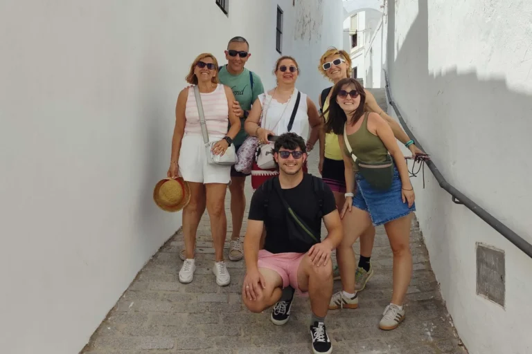 Travelers posing in a narrow whitewashed alley