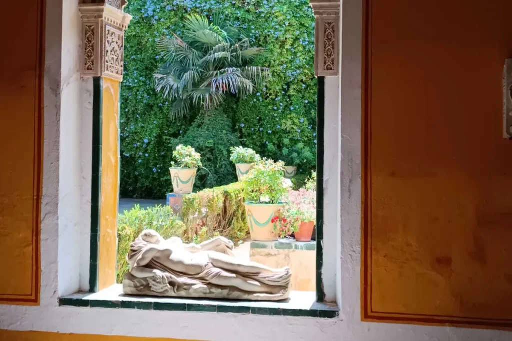 A window opening onto the garden of the Casa de Pilatos, with a reclining marble figure