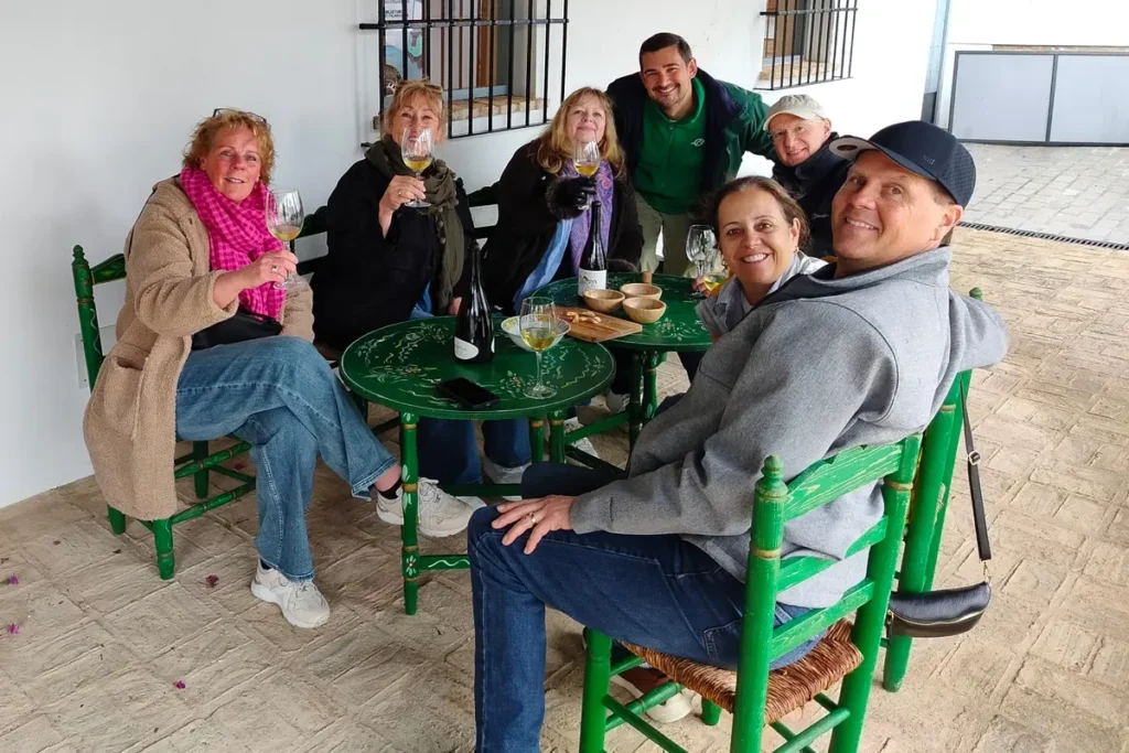 Visitors seated outdoors with glasses of wine at an Andalusian winery
